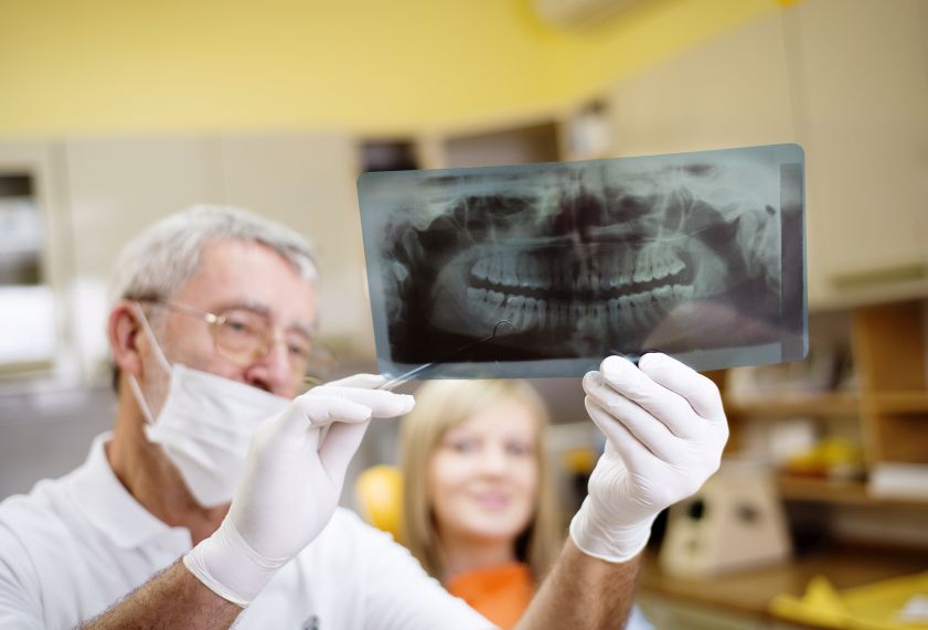 [company_name_branding] dentista mostrando una radiografía