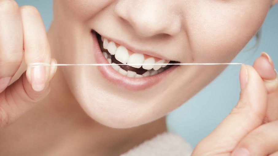 [company_name_branding] persona sosteniendo un hilo dental